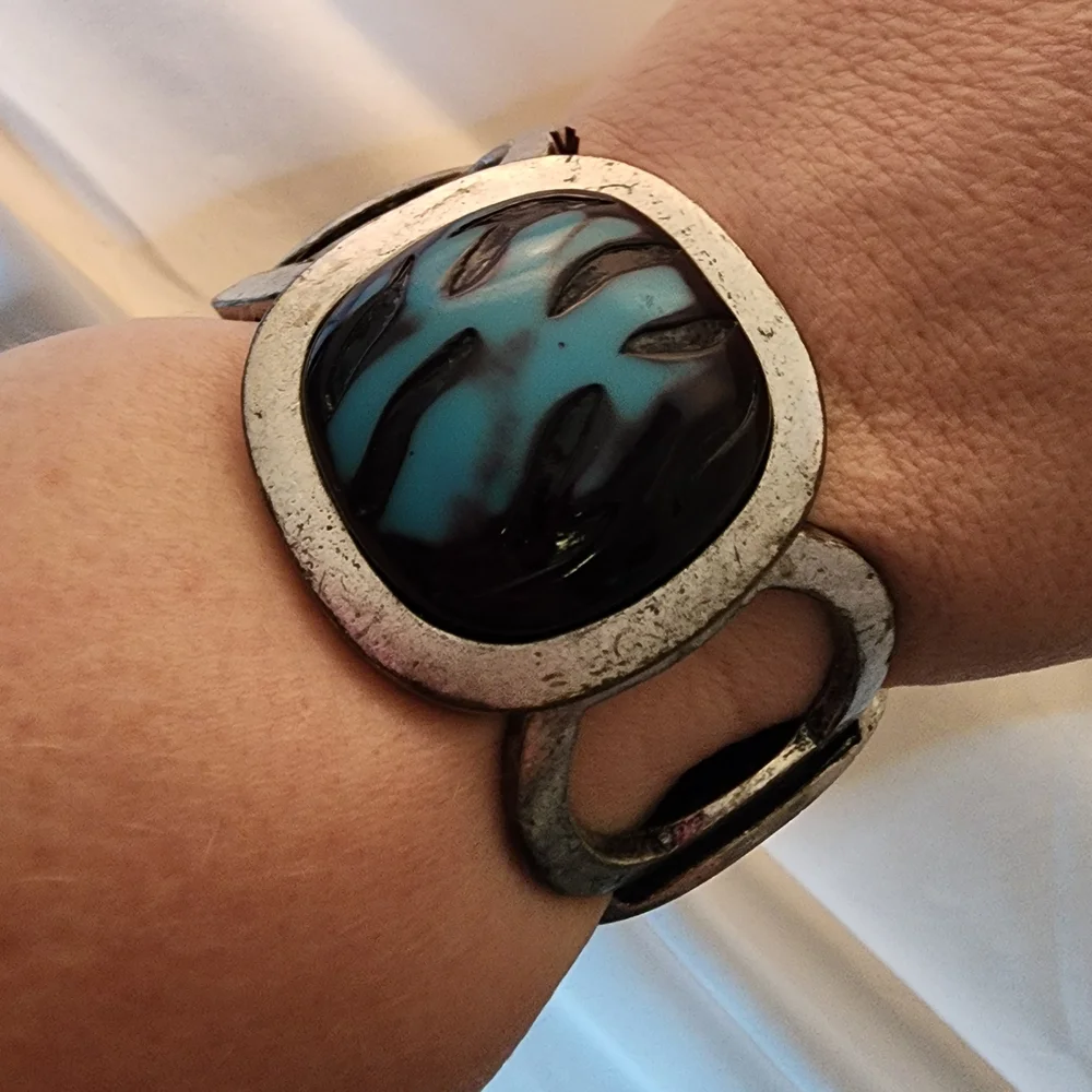 Cuff bracelet with a large, square, blue and black stone set in a Silver Tone